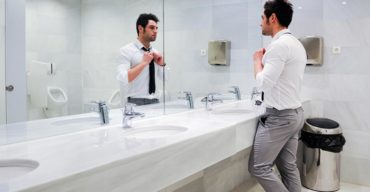 Homem usando o banheiro comercial pensando em implantar tecnologia no banheiro